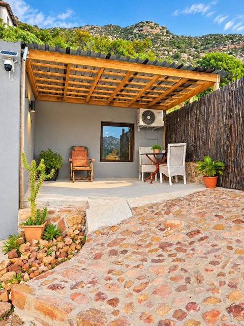 Mountain-view outdoor patio with a private dining table and chairs, overlooking Fish Hoek and the surrounding mountains.