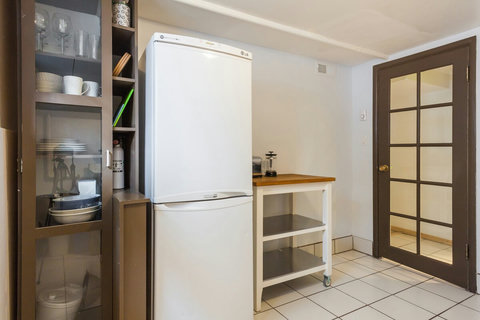 The kitchen is stocked with dishes, pots, pans, cutlery, stove, microwave, spices, oil, etc. 
