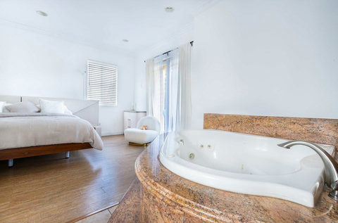 Master suite featuring a spa tub with jets, walk in shower, and private en suite bathroom.