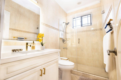 First floor guest bathroom with walk in glass shower and modern vanity.