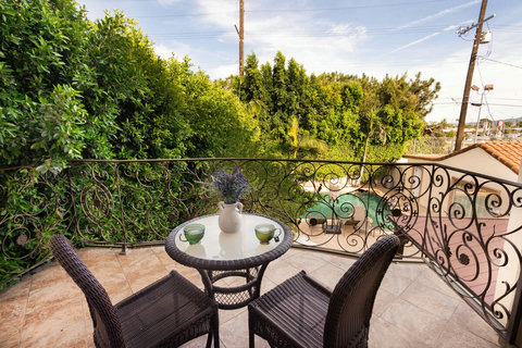 Private balcony connected to the master suite with seating for two and views overlooking the backyard and pool area.