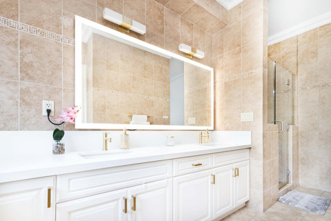 Spacious master suite bathroom with double vanity and walk in glass shower.