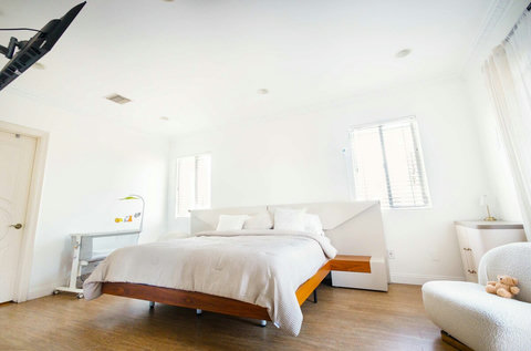 Spacious master bedroom with a king bed, minimalist design, and plenty of natural light.