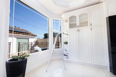 Sunlit kitchen corner with large windows and a telescope for enjoying the view.