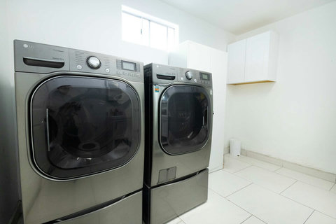 Dedicated laundry area equipped with a full size washer and dryer, offering convenient access for longer stays.