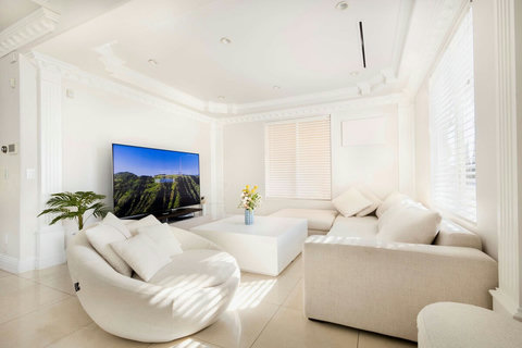 First floor living room with smart TV and large windows.
