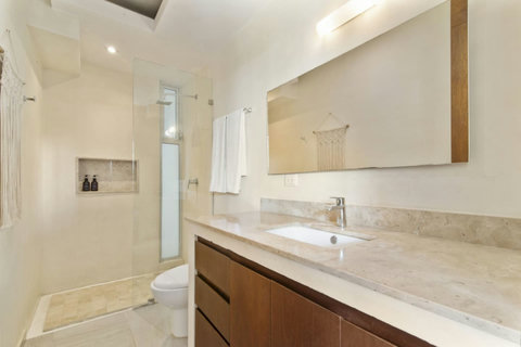 Relax and unwind in our spacious master bathroom, complete with ample storage for all your toiletries and a serene atmosphere for relaxation!  #SereneSpace #TulumLuxury #ComfortAndStyle