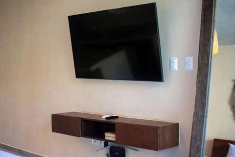 Wall-mounted Smart TV with modern floating shelf and fast Wi-Fi,  perfect for a cozy movie night or streaming your favorite shows.