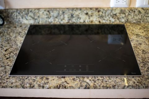 Modern black glass cooktop built into a granite counter — perfect for cooking your favorite meals with style.