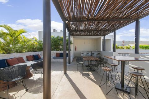 Rooftop social area with shaded seating, high-top tables, and cozy lounge benches—perfect for relaxing, dining, or enjoying a sunny day with friends.