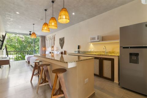 Enjoy meals or work comfortably at the granite island with bar stools and warm pendant lighting — all while taking in lush views through the floor-to-ceiling windows