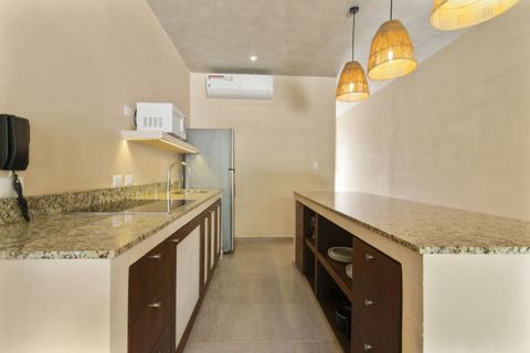 Spacious open kitchen with granite countertops, fridge, microwave, and warm pendant lighting,  fully equipped for your stay.