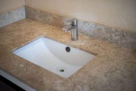 Elegant bathroom sink with a modern chrome faucet and marble countertop, offering a clean and stylish space for your daily routine.