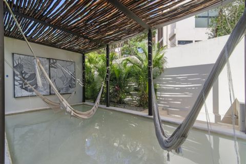 Relax in style with these hammocks suspended over shallow water, shaded by a rustic pergola and surrounded by tropical greenery—your perfect spot to unwind.