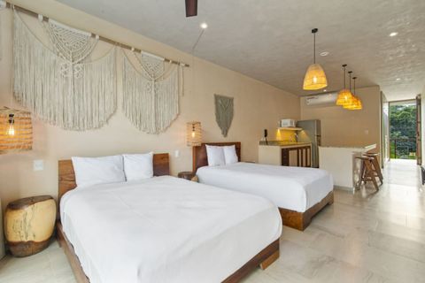 Boho-chic studio with two cozy beds, handcrafted decor, a full kitchen, and warm pendant lighting—perfect for a stylish and relaxing stay.