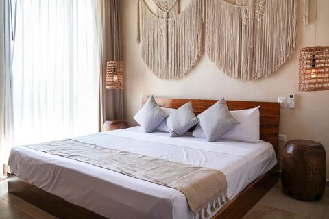 The master bedroom has been decorated in style with beautiful lamps and a fantastic Makrame in the background. The bed is extra comfortable too