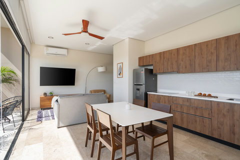 Elegant kitchen and dining area featuring wood tones, stone flooring, and a modern design perfect for relaxed gatherings.