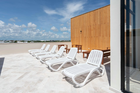Unwind on the rooftop deck featuring comfortable sunbeds and seating areas—ideal for sunbathing, reading, or simply relaxing and sharing tranquil moments with friends.