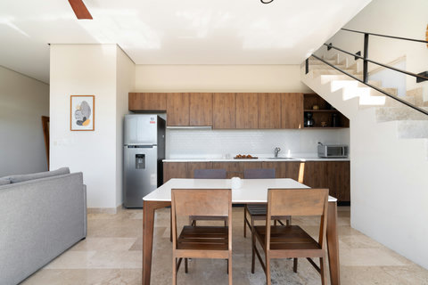 Bright kitchen with built-in cabinets, spacious counter, and cozy dining table under soft natural light.