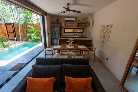 Spacious open-plan living room with a fully equipped kitchen, dining area, and poolside access for a luxurious stay.