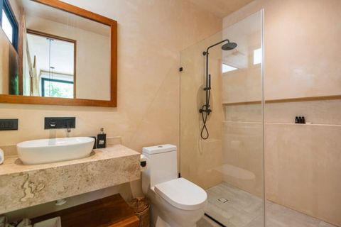 Modern full bathroom with a sleek walk-in shower, rainfall showerhead, and glass partition. Features a stylish stone countertop, vessel sink, and warm wood accents for a minimalist, elegant look