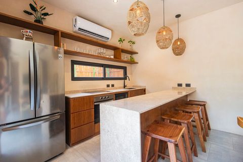 Stylish kitchen with a breakfast bar featuring a stone countertop, wooden barstools, woven pendant lights, and a warm ambiance. Perfect mix of elegance and functionality.