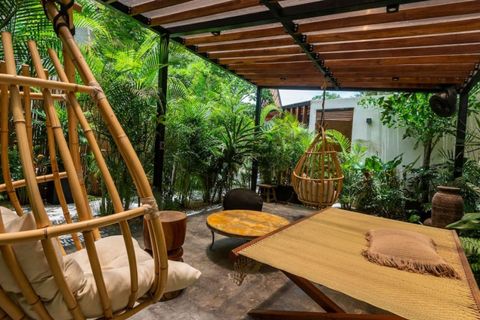 Relaxing jungle-inspired patio with bamboo furniture, a pergola for shade, and comfortable seating surrounded by vibrant tropical plants.