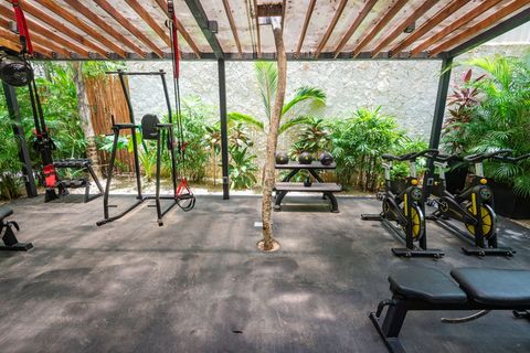 Well-equipped open-air gym with resistance training equipment, surrounded by lush greenery for an energizing workout experience.