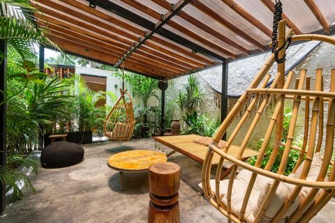 Cozy outdoor lounge with a wooden pergola, hanging chairs, and lush greenery. A perfect spot to unwind and enjoy the natural surroundings.