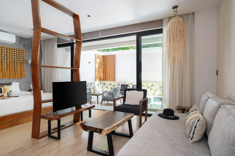 Spacious living area featuring a comfortable sofa, TV, and coffee table. Guests have direct access to the private patio, offering a seamless space to relax and enjoy the outdoors
