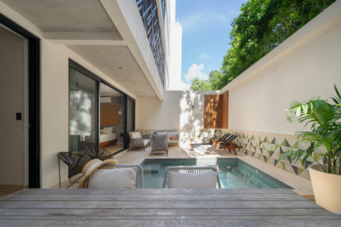 This private patio features a plunge pool and outdoor dining area. Guests can relax, soak up the sun, or enjoy meals in a calm, secluded space designed for comfort and privacy