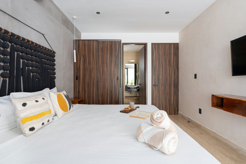 Spacious bedroom featuring a comfortable king-size bed, TV, and closet, with a private en-suite bathroom. Perfect for relaxing, resting, and enjoying privacy during your stay.