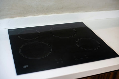 The kitchen features a modern induction cooktop with a sleek, black glass surface, offering a stylish and efficient cooking experience.