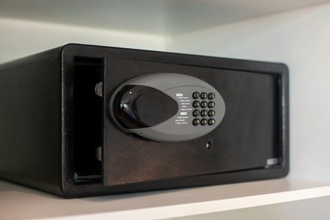 The photo shows a secure electronic safe with a keypad, providing guests a secure spot to store valuables during the stay.
