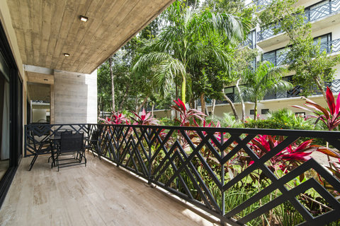 Unwind on a spacious terrace surrounded by lush tropical plants. Enjoy comfortable seating, serene views, and the perfect setting for peaceful outdoor moments.