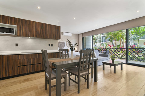 Enjoy a stylish open-plan space with a modern kitchen, sleek cabinetry, and dining area. Relax in the cozy living room while taking in peaceful views of lush greenery.
