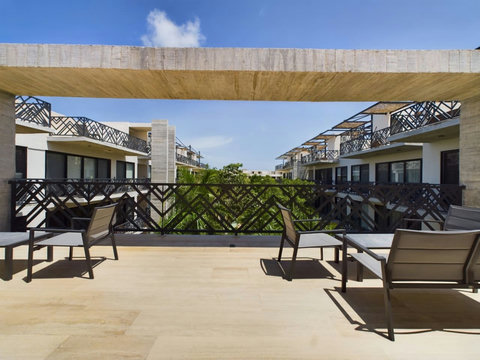 Relax in Palais Tulum charming terrace, featuring cozy armchairs perfect for basking in the sun or unwinding in serene surroundings. Your tranquil escape awaits.