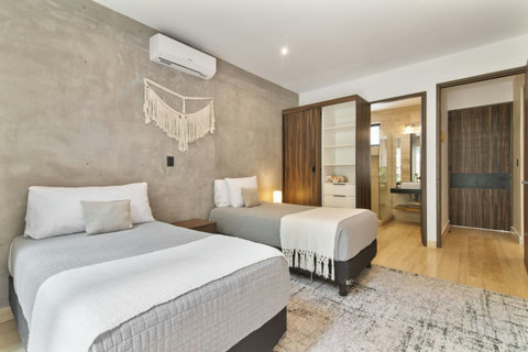 Cozy and stylish twin room with boho decor, AC, built-in closet, and a private bathroom—perfect for friends or family traveling together.