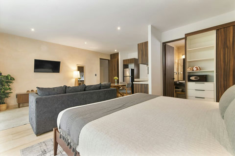 Modern studio with king bed, smart TV, full kitchen, dining area, spacious closet, and a sleek bathroom—perfect for a stylish and comfortable stay.