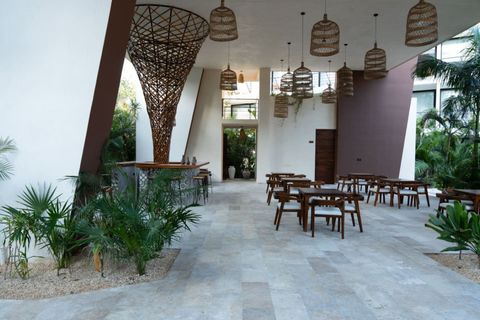 Open-air dining area with wooden tables and chairs, lush greenery, and a stunning sculptural bar centerpiece under woven pendant lights for a relaxed and stylish vibe.
