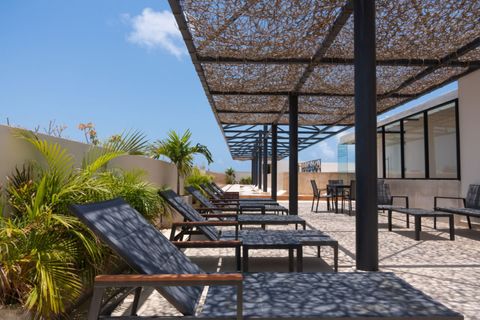 Experience the beauty of Palais Tulum's captivating terrace, furnished with comfortable chairs an inviting haven for relaxation and enjoying sunlit moments, perfect for unwinding and cherishing tranquility