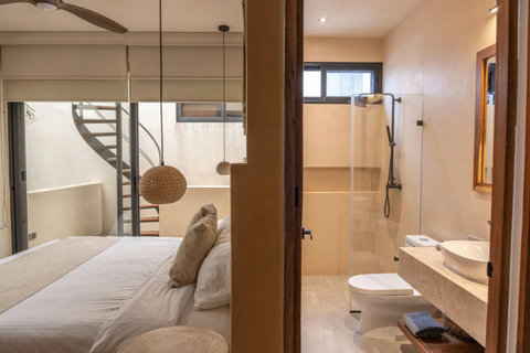 Luxurious comfort awaits in the main bedroom with a king-size bed and a private patio, offering serene green spaces for your relaxation and delight.