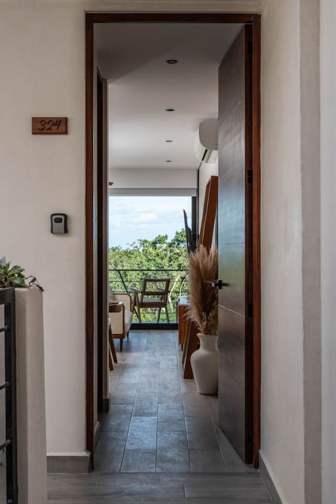 Step into elegance at our beautifully designed apartment entrance! Bathed in natural light, it creates a warm and inviting atmosphere. Enjoy a seamless check-in experience via our convenient lockbox, setting the tone for a stress-free stay in Tulum!