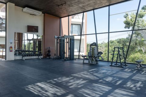 Stay fit in the shared gym featuring state-of-the-art equipment and floor-to-ceiling windows that offer stunning views of the lush surroundings.
