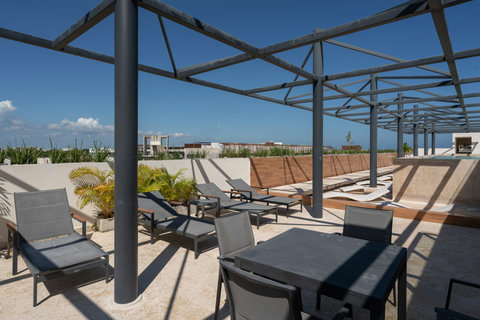 Palais Tulum invites you to its terrace, with cozy armchairs perfect for sunbathing or relaxing. Your serene retreat awaits.