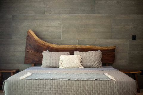 King bed with artisanal wood headboard, plush pillows, and premium linens—perfect for a restful and stylish stay.