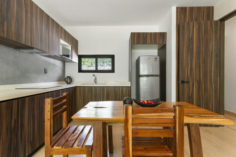 A modern, fully equipped kitchen for your home-cooked meals. Features stainless steel appliances and a beautiful, rustic wood dining table.