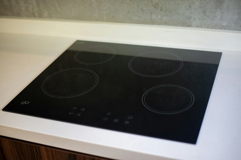 The kitchen features a modern induction cooktop with a sleek, black glass surface, offering a stylish and efficient cooking experience.