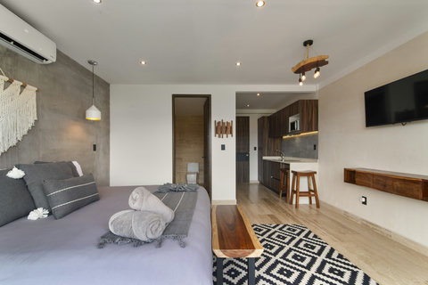 Unwind in a contemporary room with a plush bed, natural wood details, and a trendy rug. Perfect for guests craving a cozy, modern haven!
