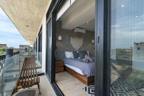 Enjoy a stylish bedroom with a cozy bed, modern decor, and a private balcony with stunning views. Perfect for guests seeking comfort and relaxation